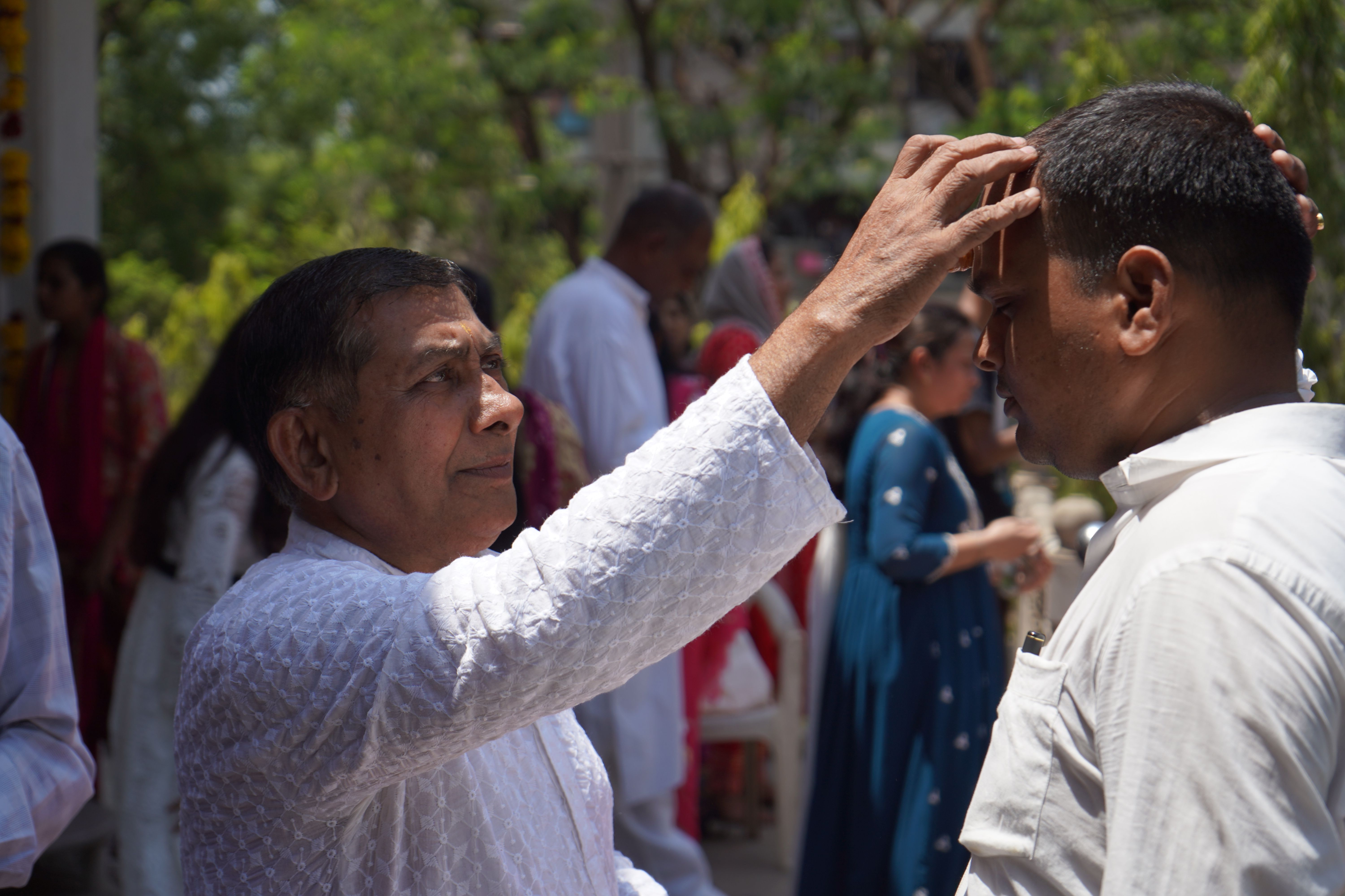 A priest gives blessings during a traditional ceremony, highlighting rich cultural practices.