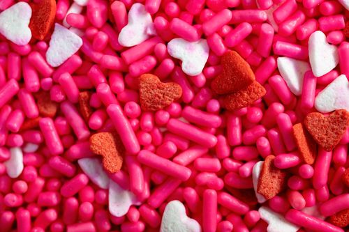 Free Vibrant close-up of pink, red, and white heart-shaped candy sprinkles. Stock Photo