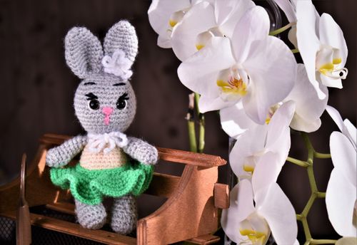 Free Adorable handmade crochet bunny next to elegant white orchids, perfect for decoration. Stock Photo