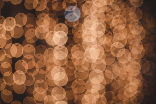 Abstract bokeh background featuring warm, golden circles creating a festive and soft decorative pattern.