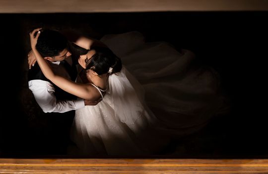 A top-down view of a bride and groom embracing during a dance, capturing the essence of love and celebration.