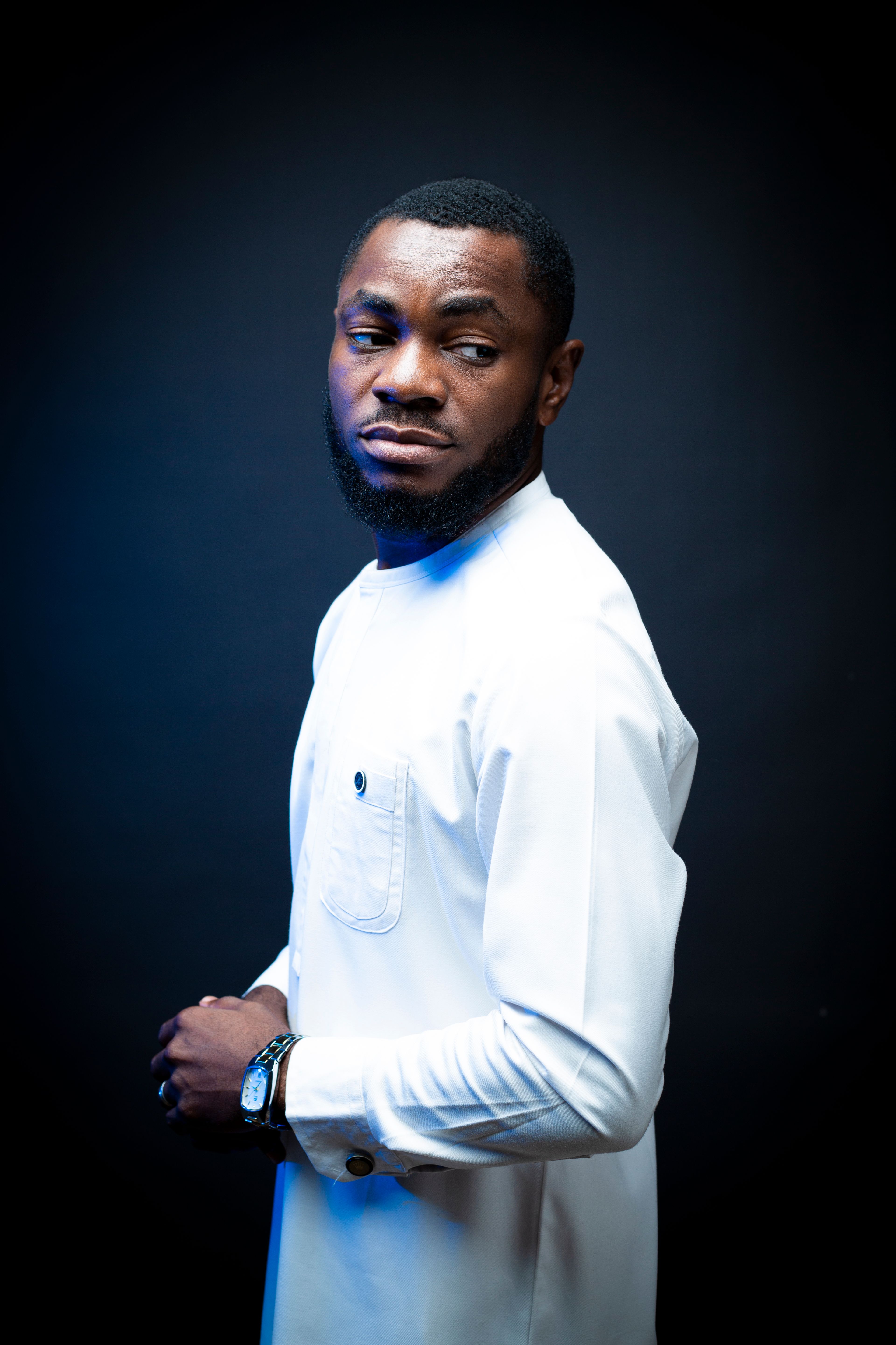 Studio portrait of an elegant man wearing a white shirt, showcasing style and confidence.