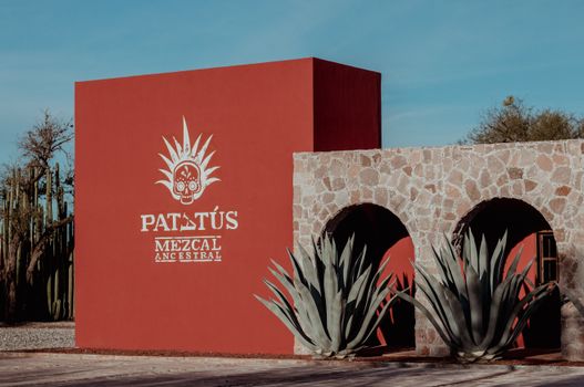 Rustic stone and adobe facade of Patatús Mezcal in Bocas, S.L.P., México, showcasing agave plants and traditional design.