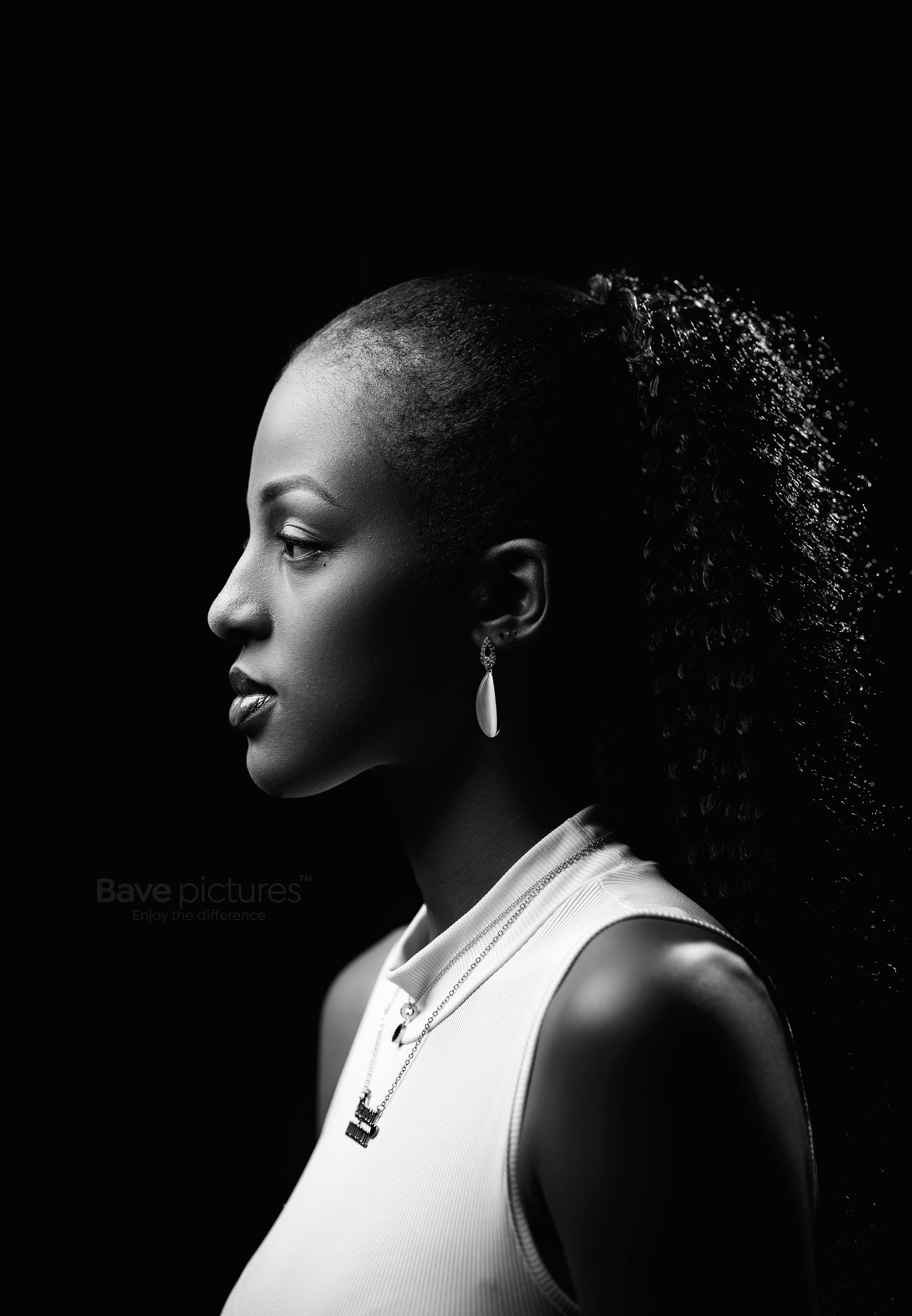 Elegant black and white portrait featuring a woman in profile with earrings and a white top.