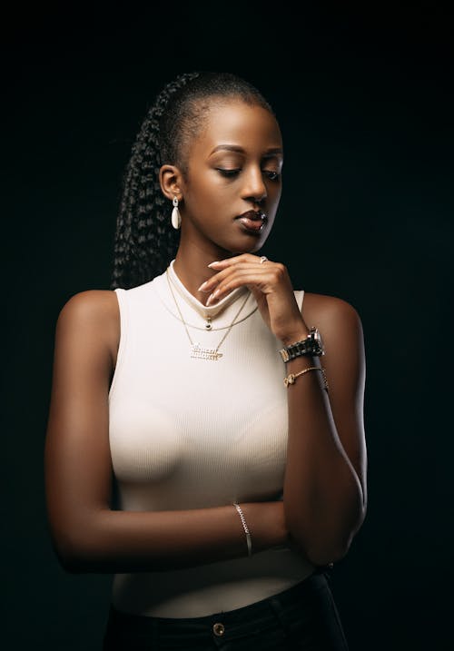 Beautiful Woman in White Sleeveless Sweater Posing in Studio