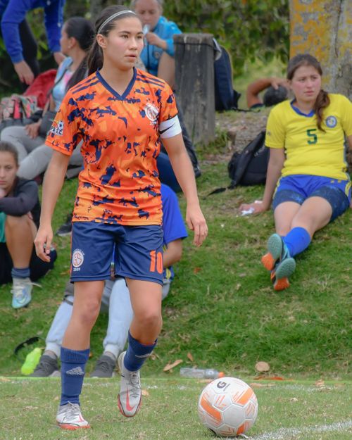 Free A young woman soccer player stands on the field during a match, ready to play. Stock Photo