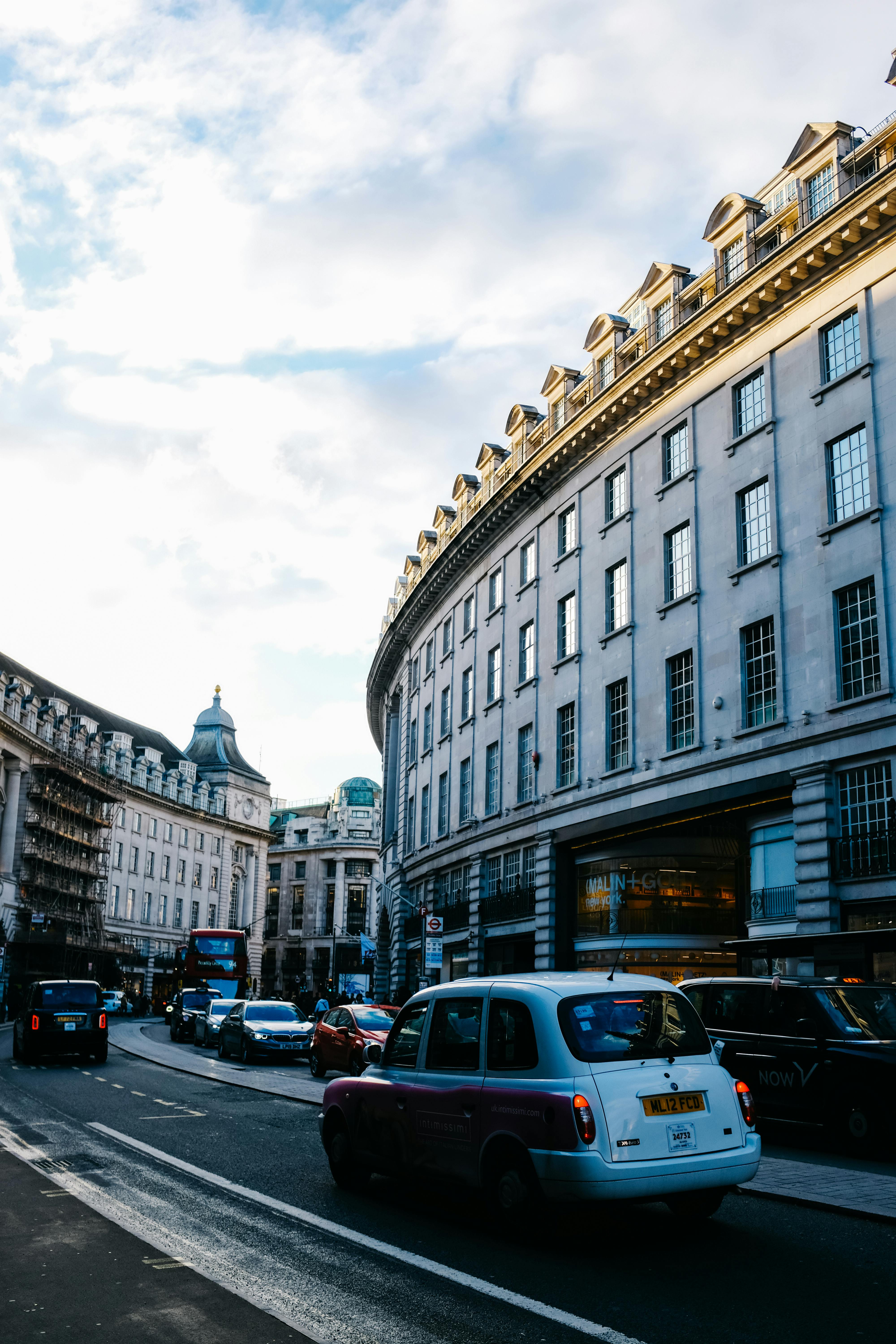 Iconic curve of Regent Street, London with taxis and vibrant city life.