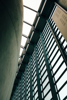 Abstract view of a modern building interior with glass ceiling and grid-like windows, showcasing architectural design.