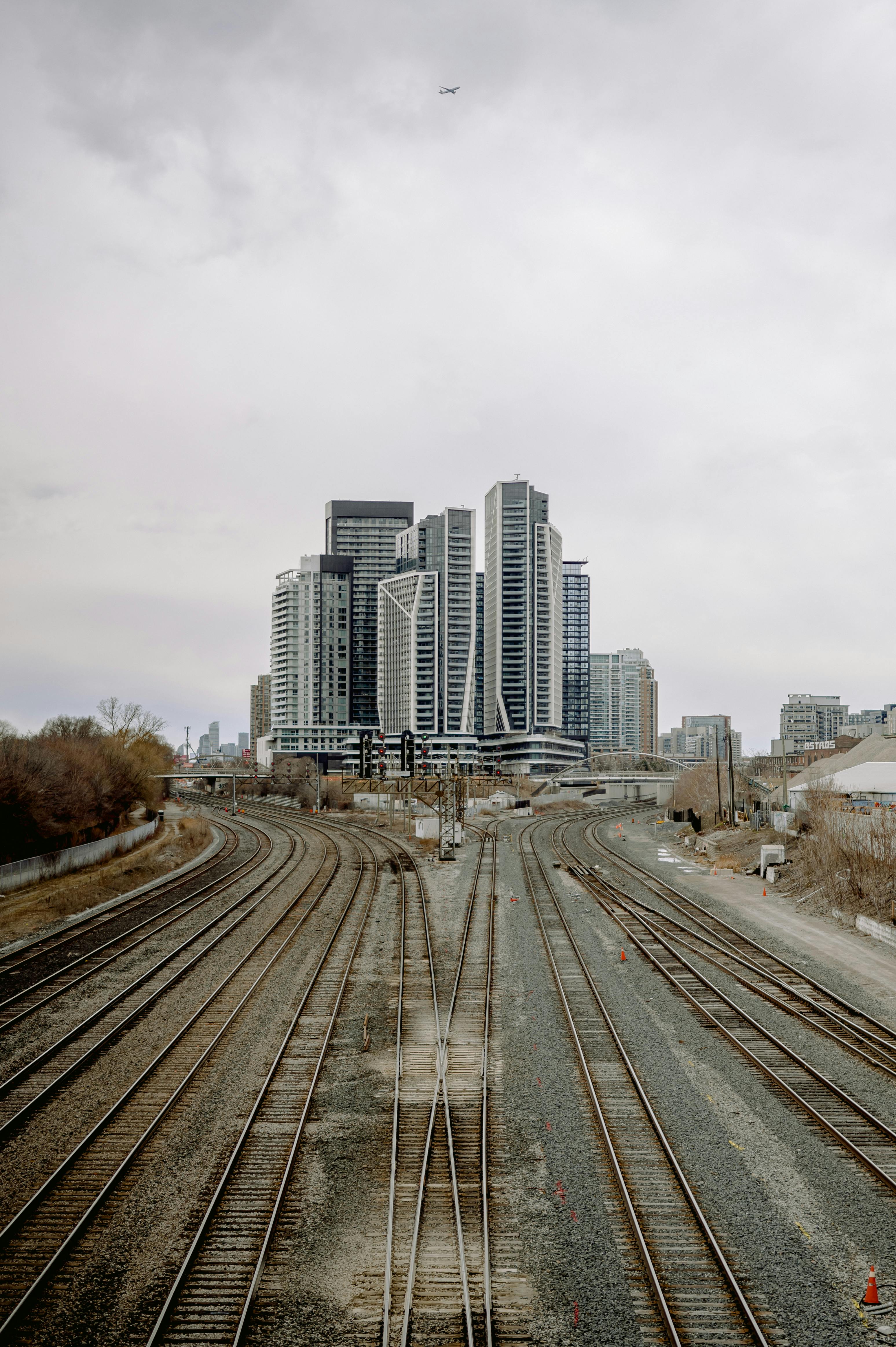 City skyline with high-rise buildings and railway tracks stretching into the distance.