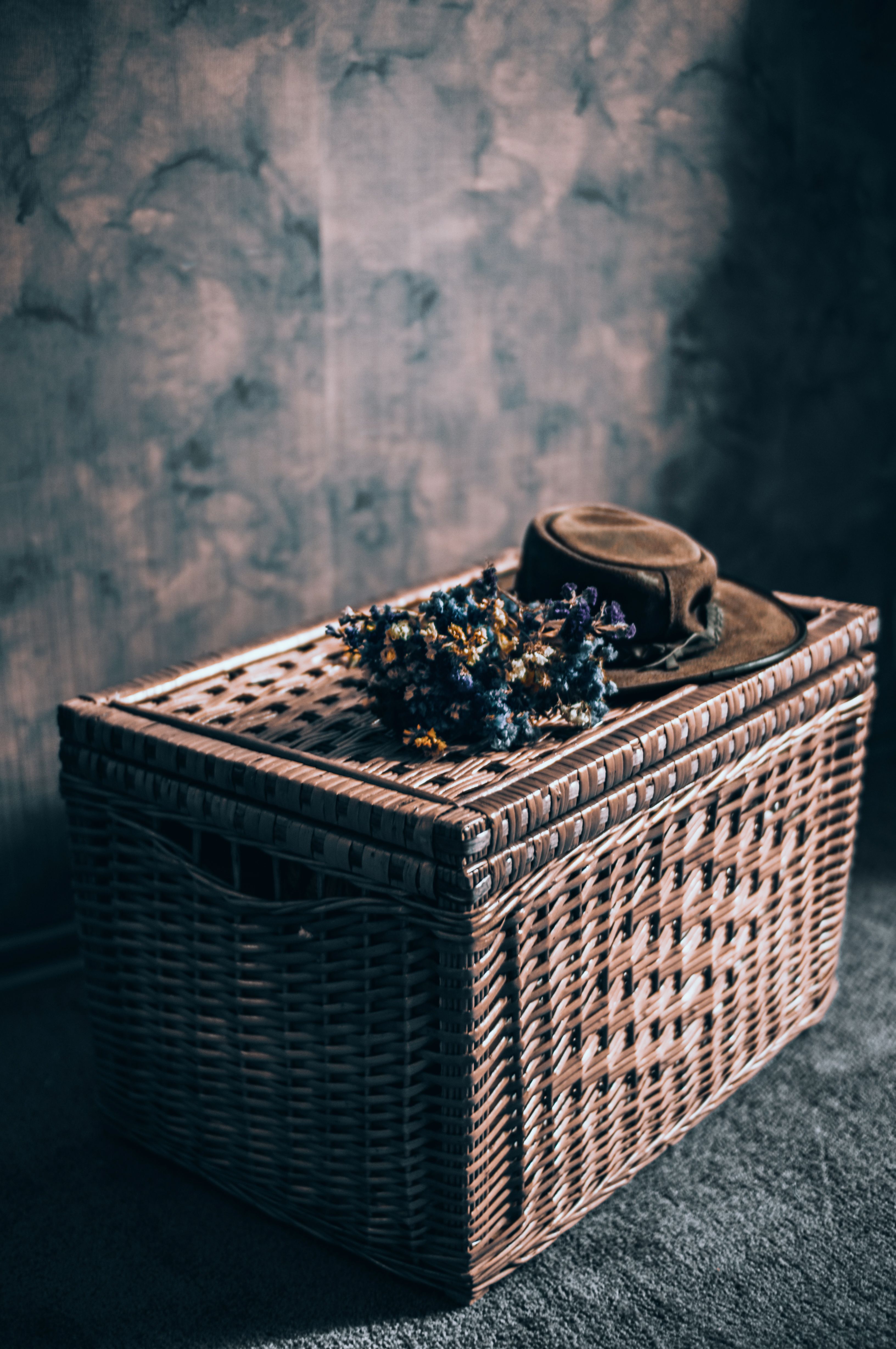 A Bunch of Flowers and a Hat on Top of a Wicker Basket · Free Stock Photo