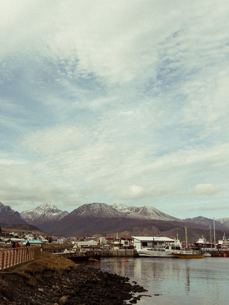 Boats In Port Against Mountains On Horizon