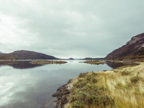 Landscape of a River and Mountains under a Cloudy Sky 