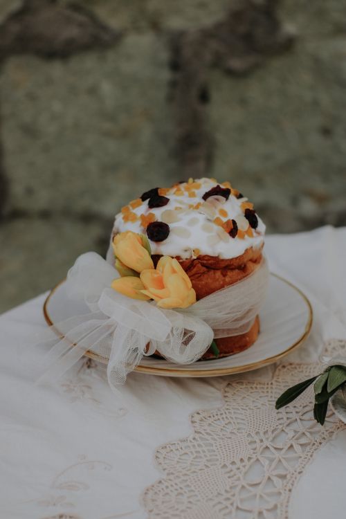 Free Beautiful Easter cake topped with dried fruits, wrapped in ribbon and adorned with flowers for a festive touch. Stock Photo