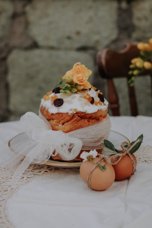 Free Easter cake decorated with fruits and flowers, adorned with eggs on a lace tablecloth. Stock Photo
