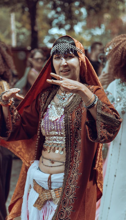Woman Wearing Traditional Cape and Jewelry Dancing at a Festival 