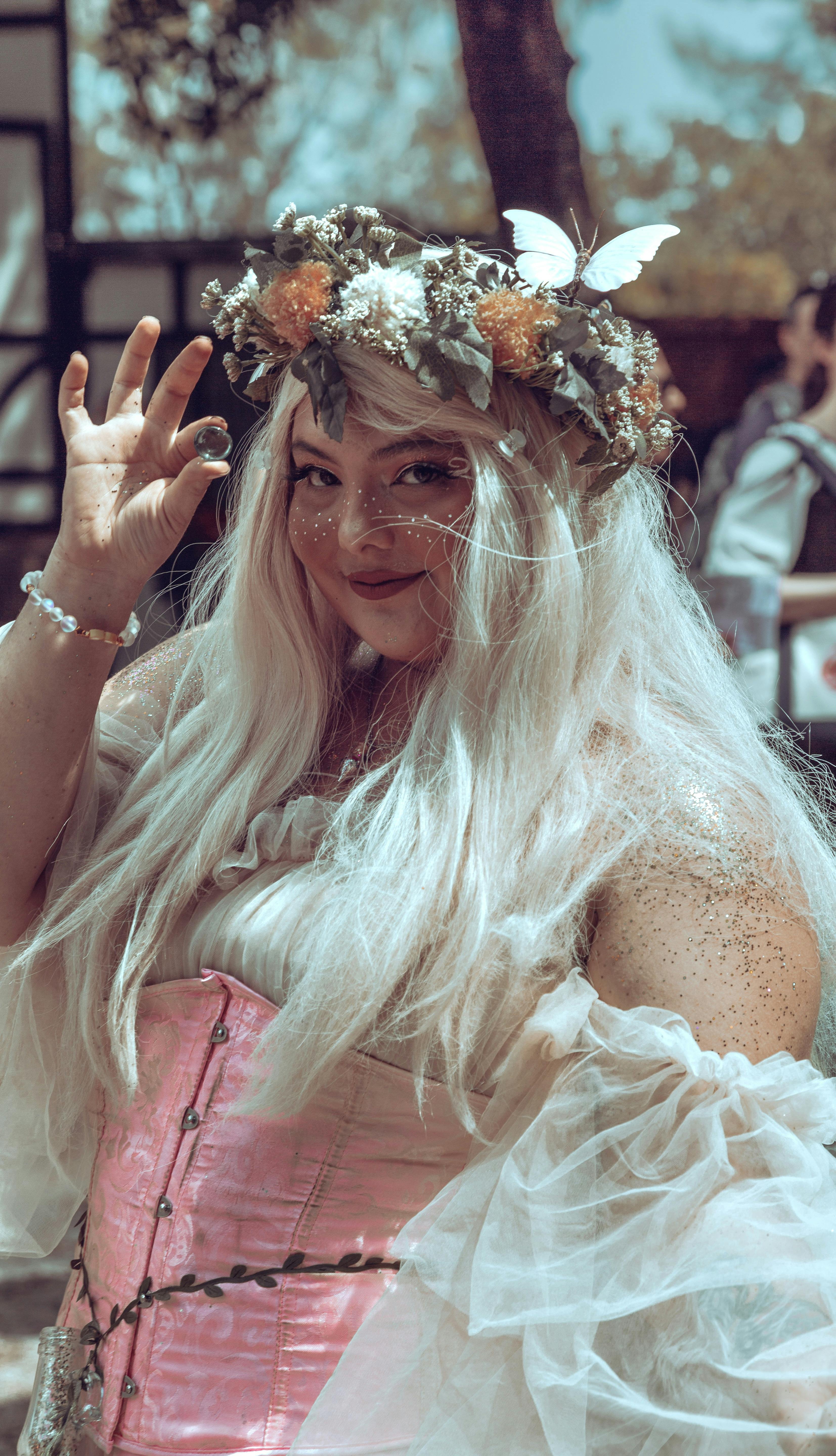 Whimsical portrait of a woman in a floral wreath and fantasy costume at a fair.
