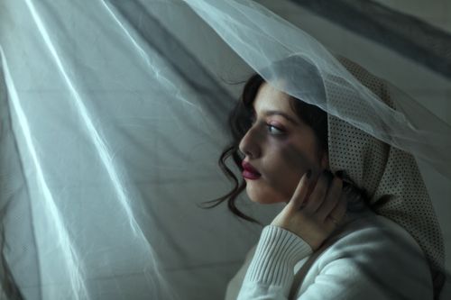 Free Artistic portrait of a woman wearing a headscarf and veil, exuding elegance. Stock Photo