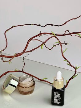 Sophisticated flat lay of skincare products with a branch on a white background.