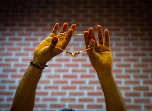 Hands Raised and Holding Bracelet