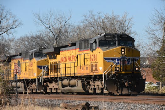 Union Pacific freight trains moving on railway tracks on a clear day.