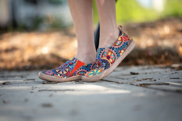 A Woman's Feet In Colorful Shoes On A Sidewalk