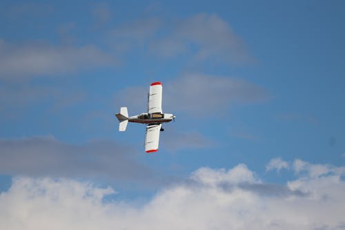 A White Plane Flying against a Blue Sky 