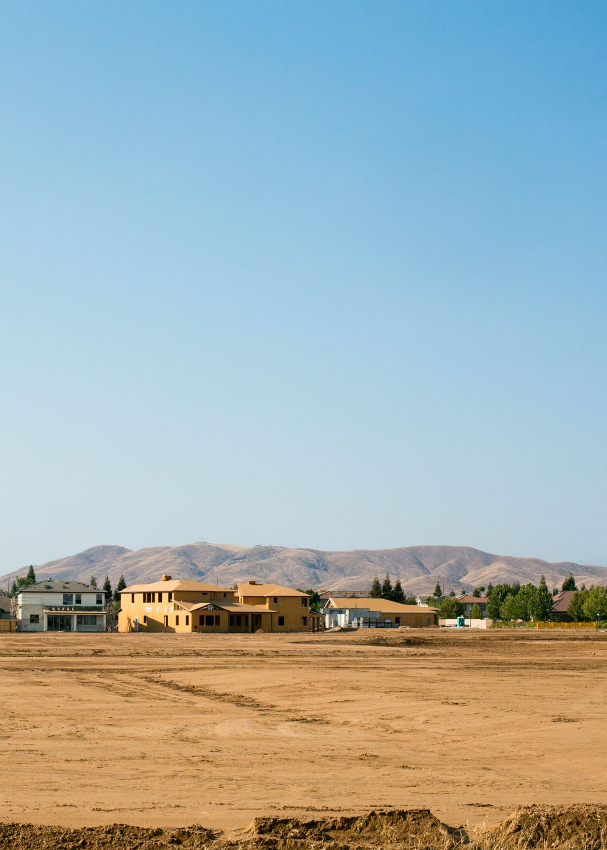 Houses on the desert edge with mountains on the horizon