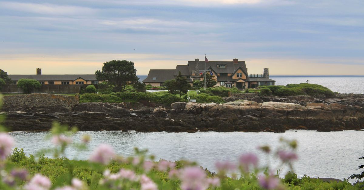 Scenic view of a coastal estate in Kennebunkport, Maine, with ocean and flowers.