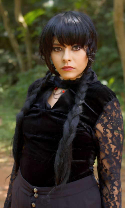 Free Portrait of a young woman in gothic attire with braided hair in a forest setting. Stock Photo