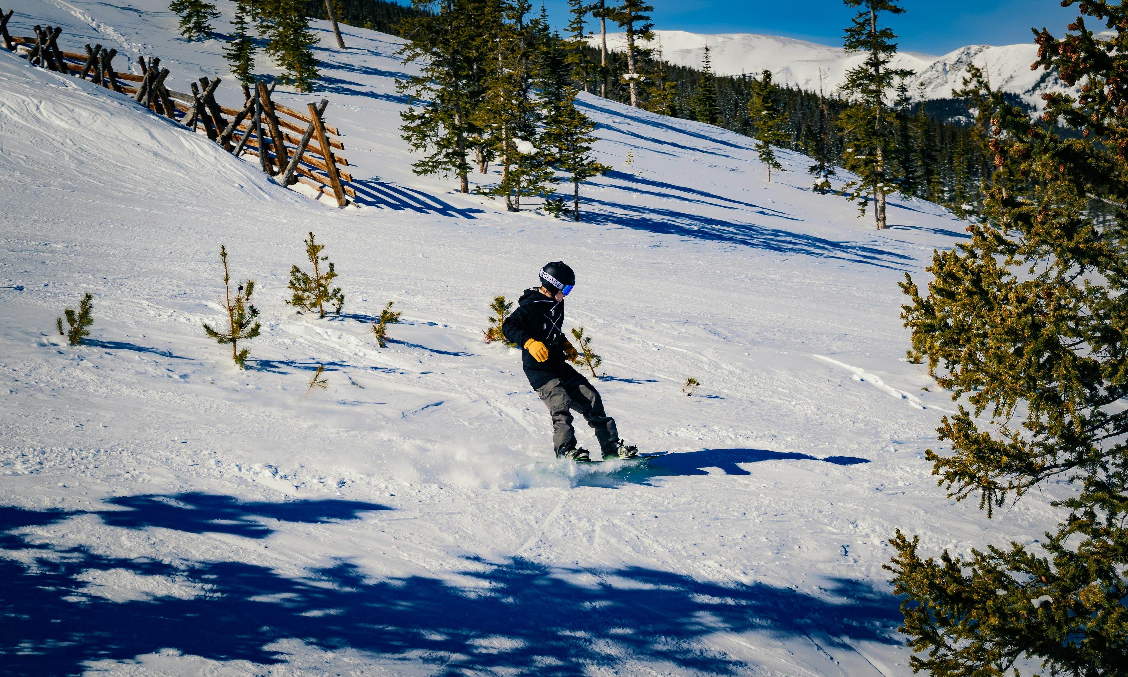 a person snowboarding down a snowy hill