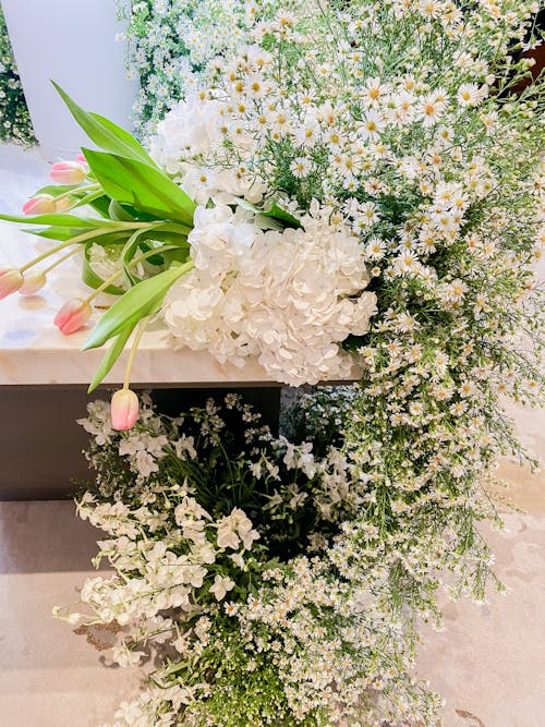 A Flower Arrangement Made from White Delicate Flowers and Tulips 