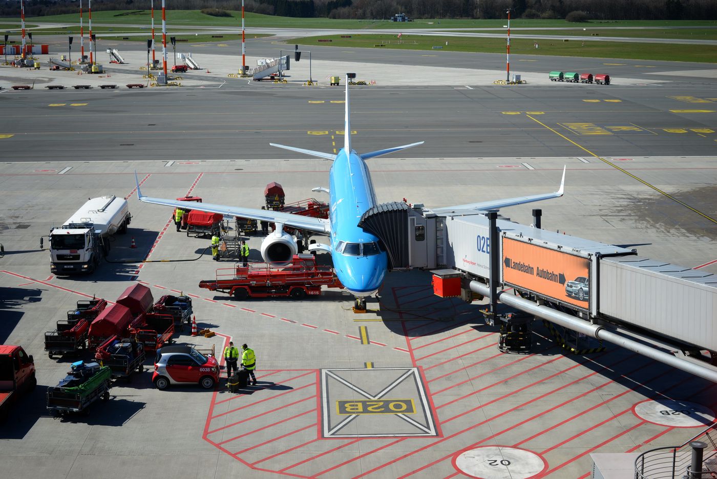 A commercial passenger airplane parked on the tarmac connected to an airport jet bridge/gate; no airline livery identifiable.