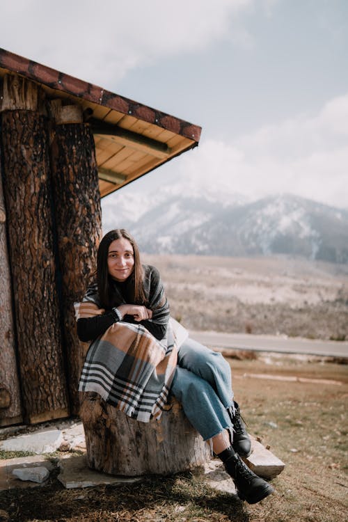 Woman Posing near Shed in Mountains