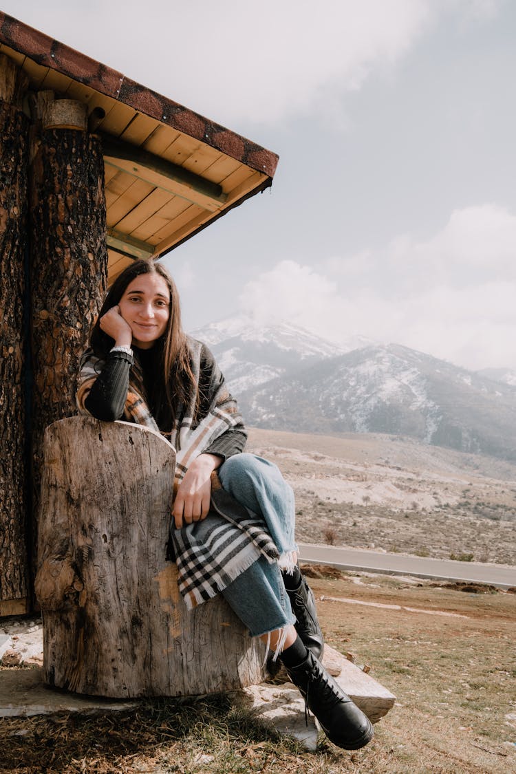Woman Posing By Wooden Shed In Mountains