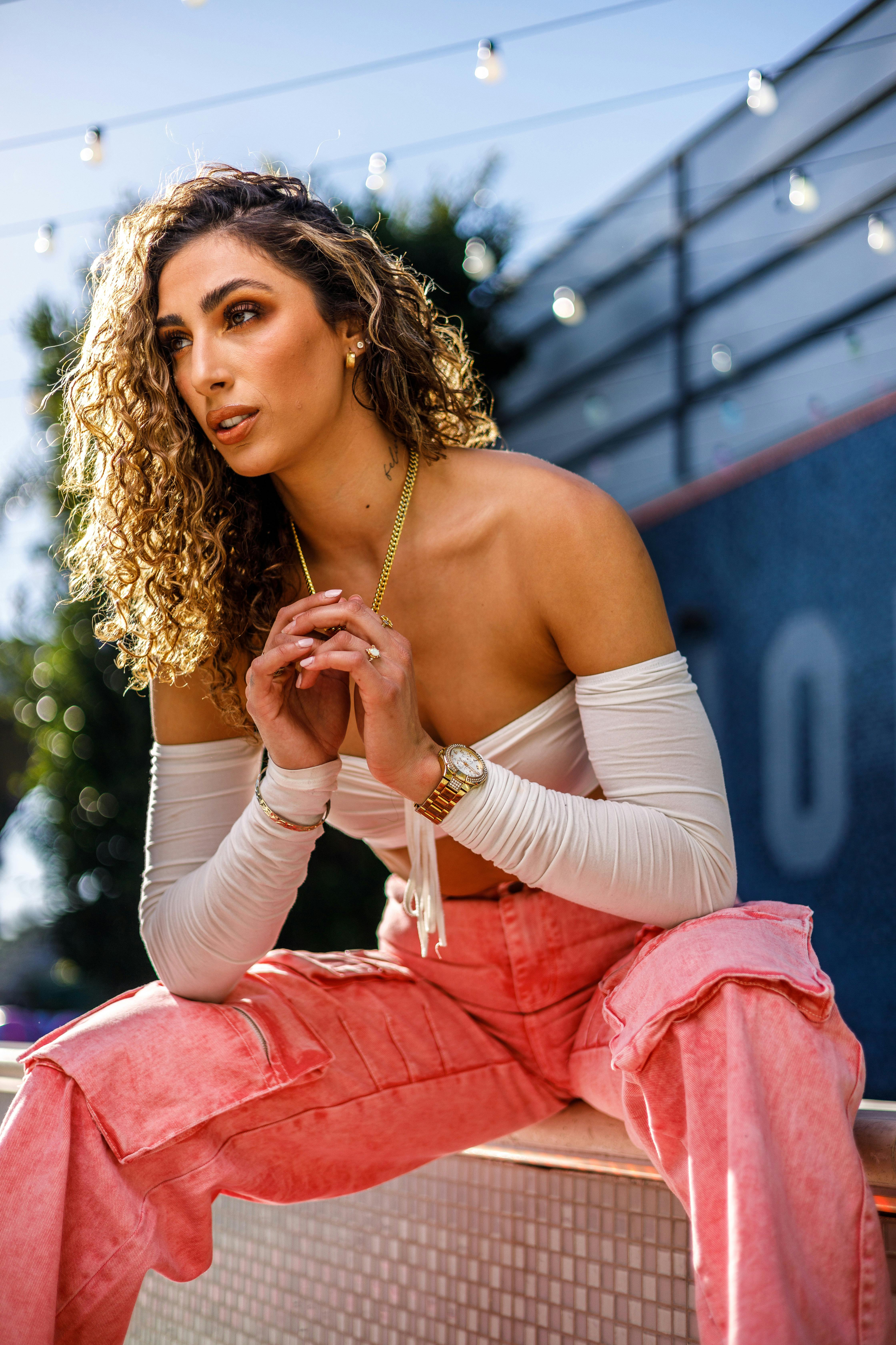 a woman in pink pants sitting on a bench