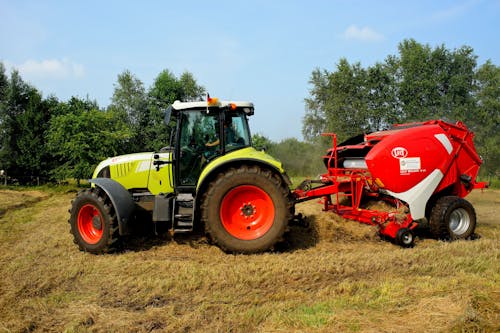 Roter Gelber Und Weißer Traktor Auf Grasfeld Während Des Tages