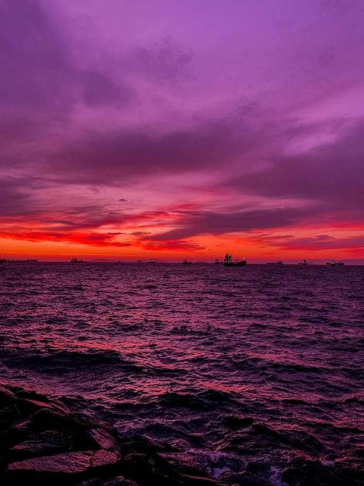 Red And Violet Sky Over A Bay Full Of Cargo Ships