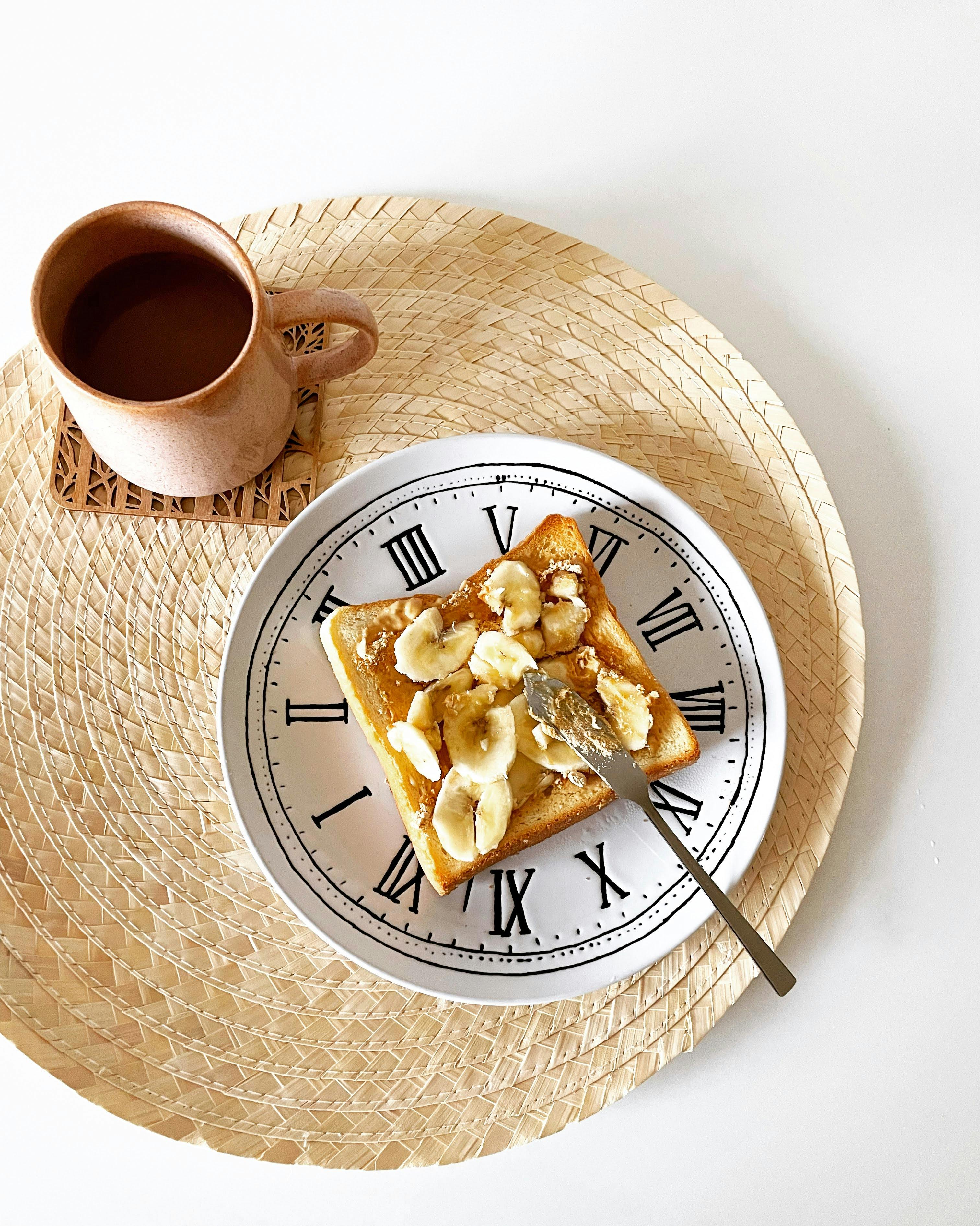 a plate with a banana and coffee on it