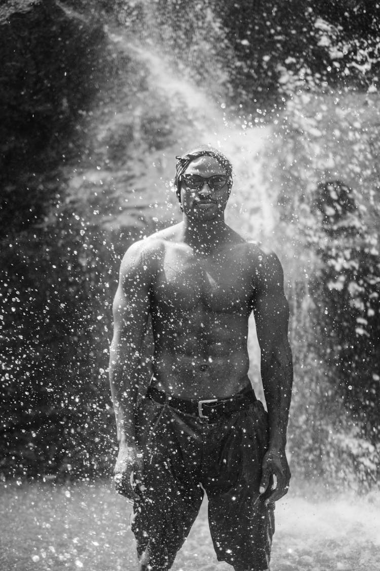 Muscular Shirtless Man Standing In Splashing Water 