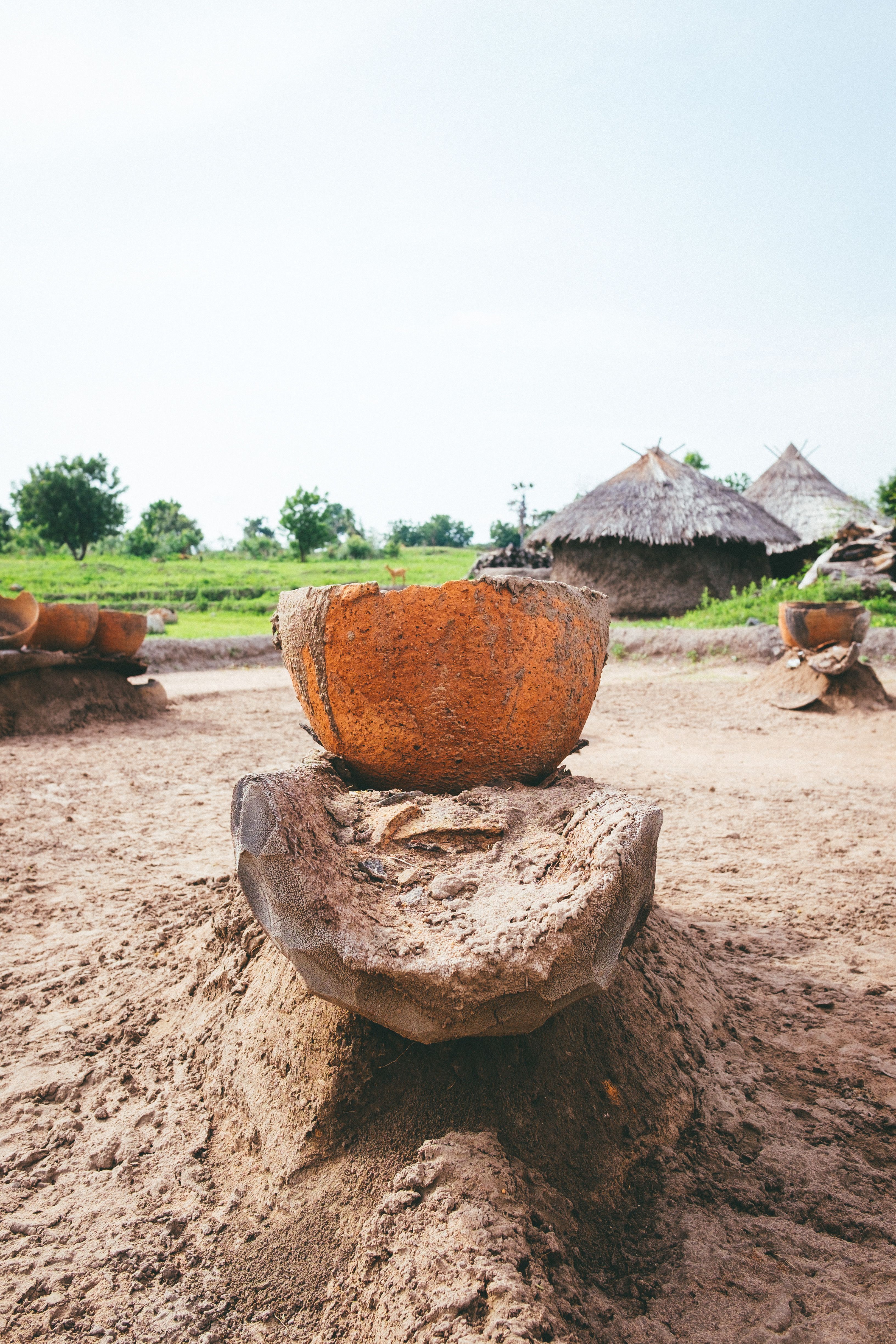 Earthen clay pots in a rural Nigerian village setting, showcasing traditional culture.