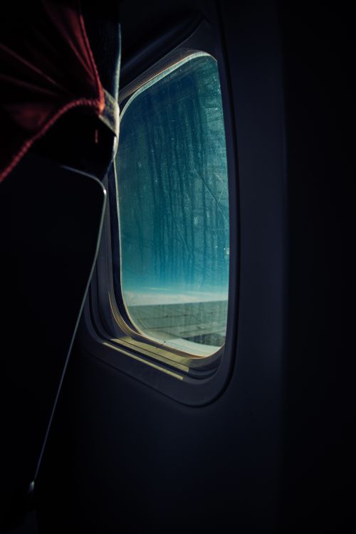 Free A captivating view of the blue sky and horizon through an airplane window during flight. Stock Photo