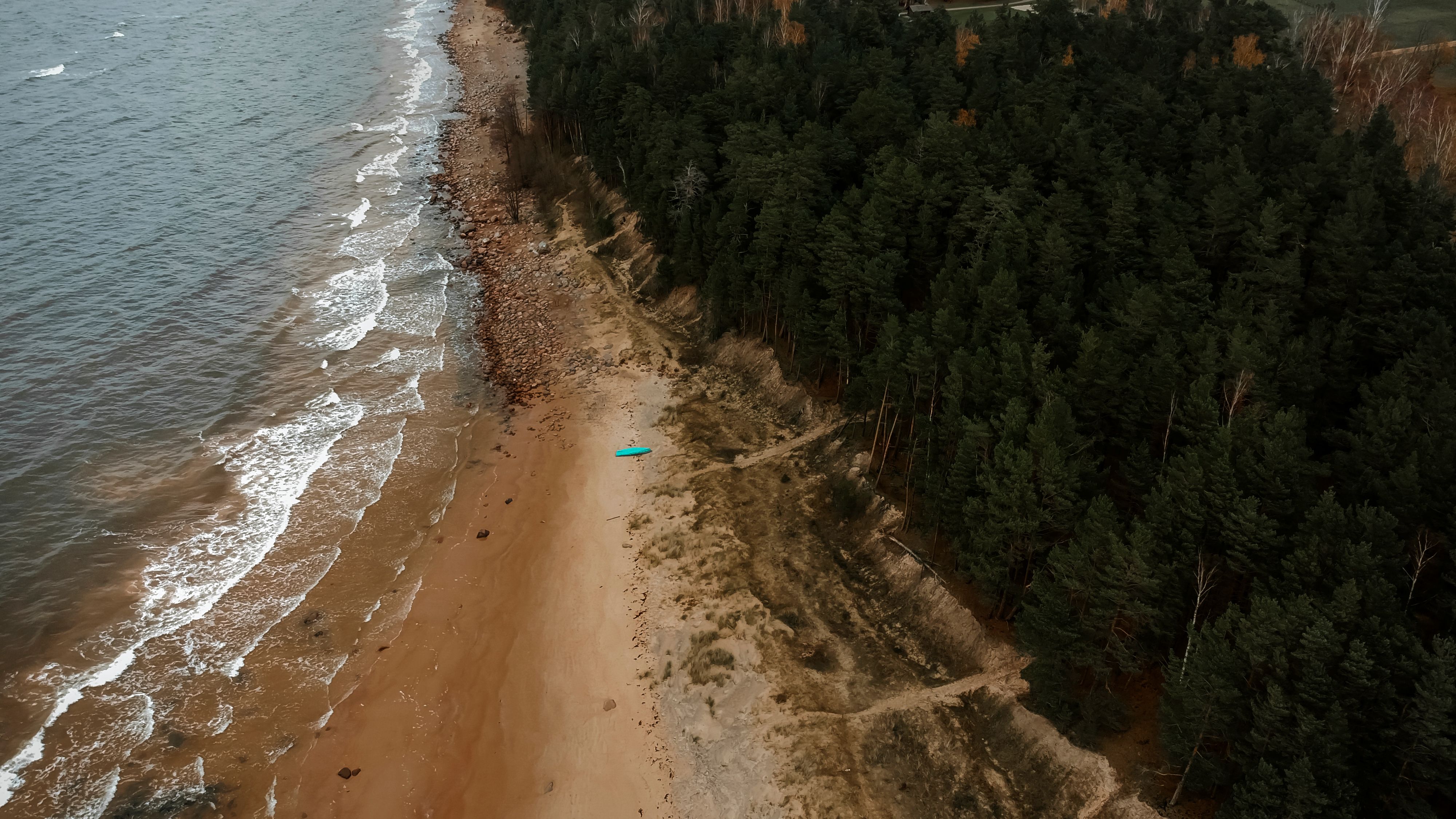 A stunning aerial view of the Ķurmrags coastline with forest and beach in Latvia.