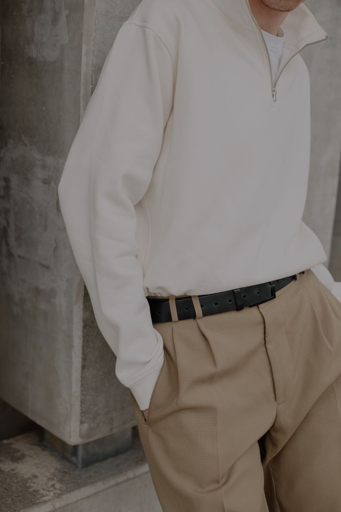 Pleated tan trousers with a cream half-zip knit — photo by Elina Volkova on Pexels