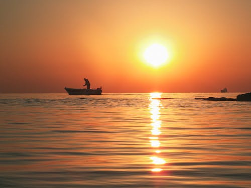 Angler Fishing from a Boat at Sunrise
