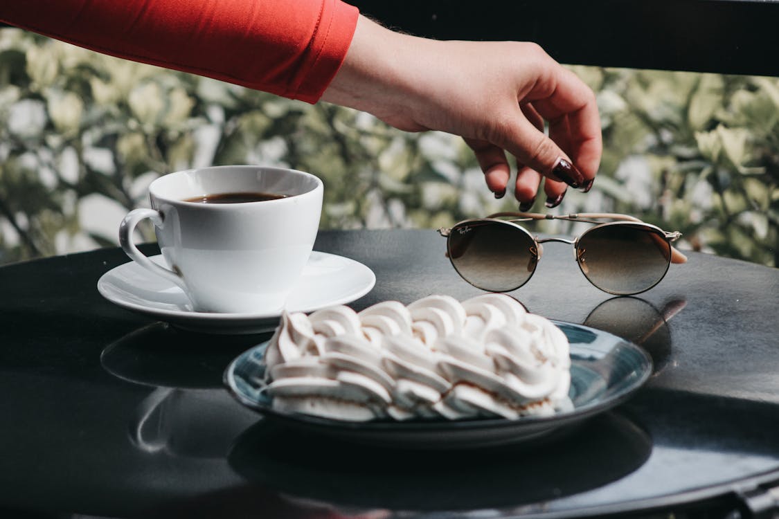 Woman Hand over Sunglasses on Table