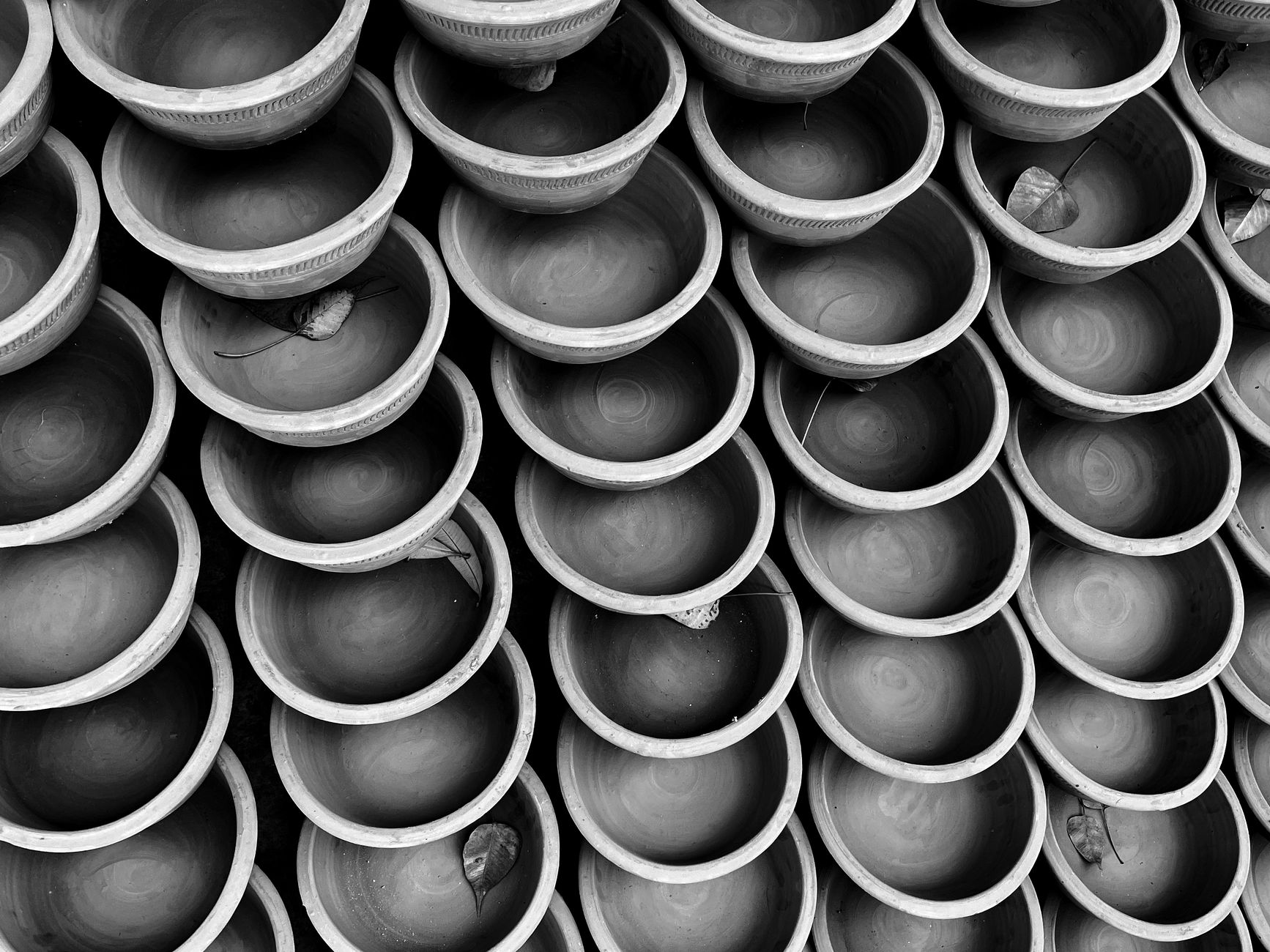 Artistic black and white photo of neatly stacked clay bowls, creating a cultural and minimalist visual.