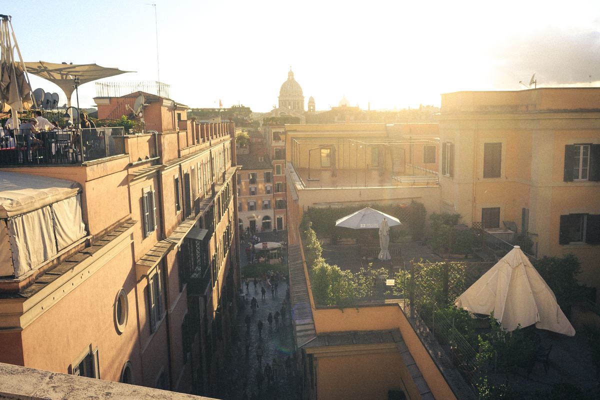 Italian rooftop terrace at sunset with golden light cocktail glasses Tuscan view