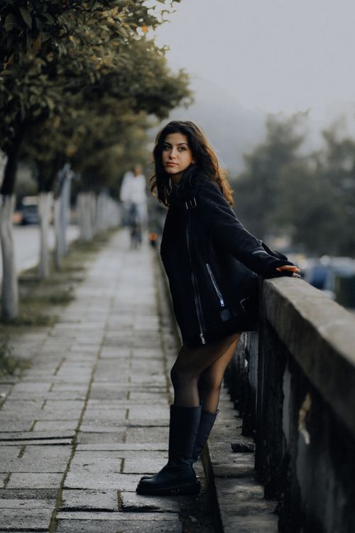 Free Fashionable young woman in a black outfit poses on a Fethiye sidewalk, embodying urban style. Stock Photo
