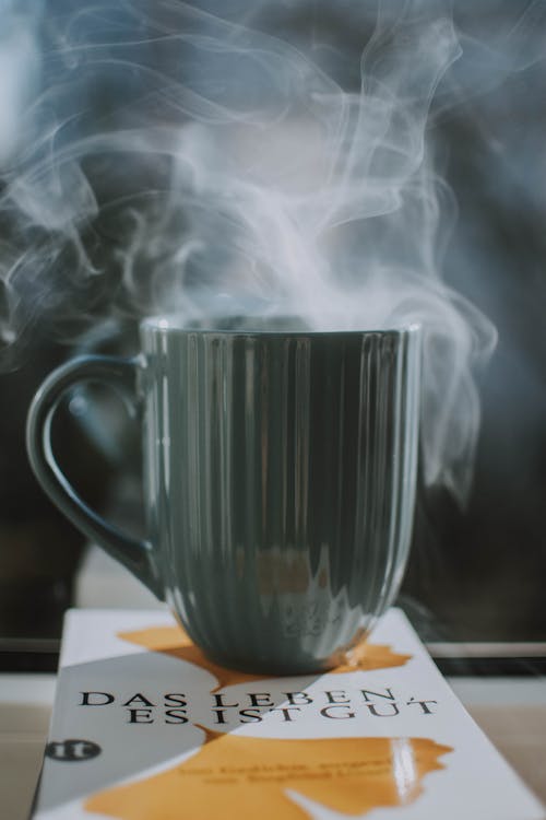 Gray Ceramic Mug on top of  Book