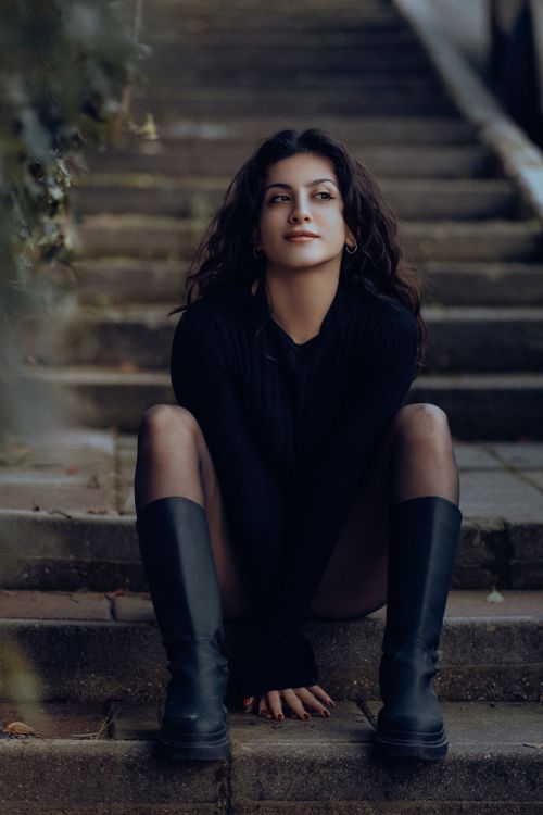 Free Portrait of a woman in black fashion, sitting on outdoor steps in Fethiye, Turkey. Stock Photo